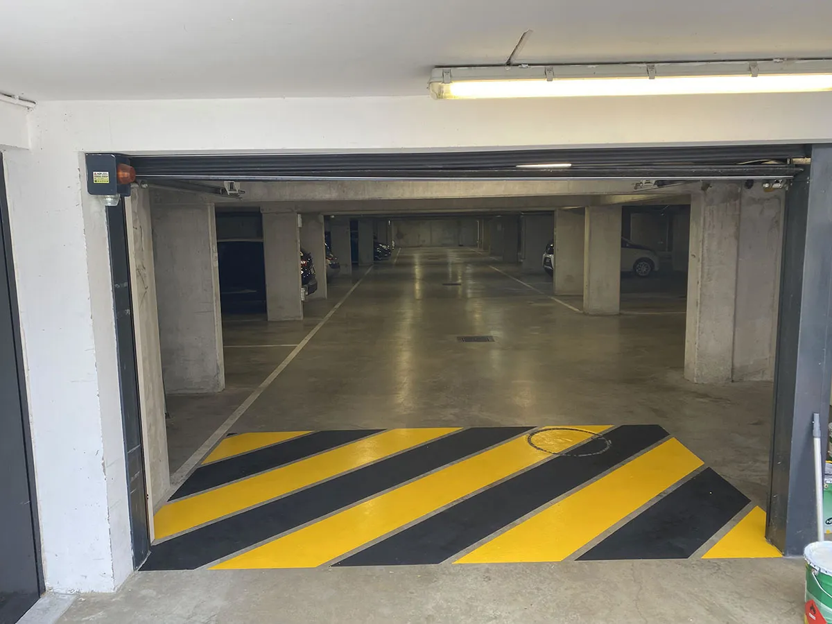 Zébra noir et jaune devant l’entrée d’un parking couvert