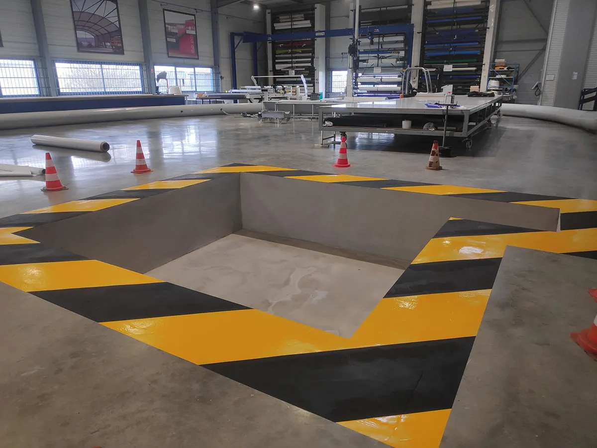 Zébra noir et jaune tracé autour d’une fosse dans un atelier