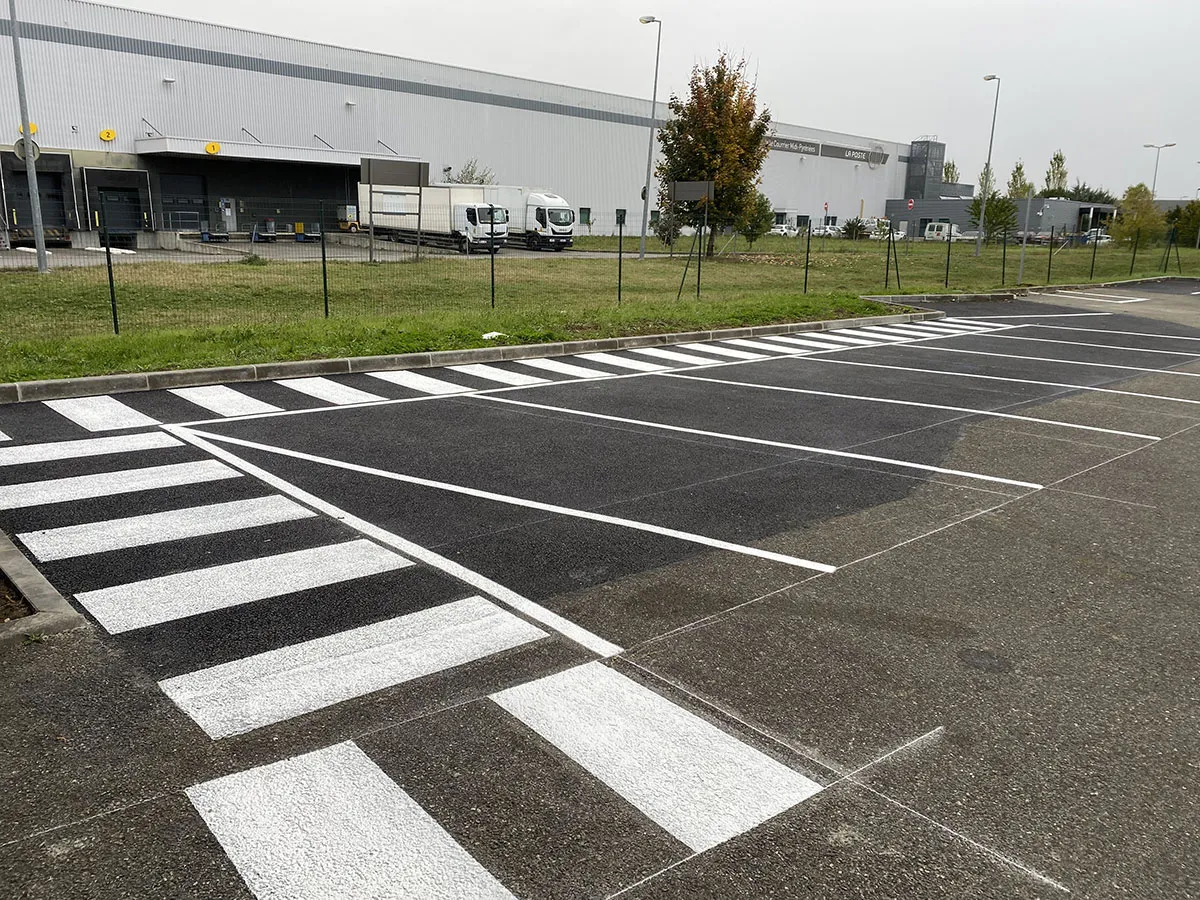 Passage piéton blanc reliant un parking professionnel