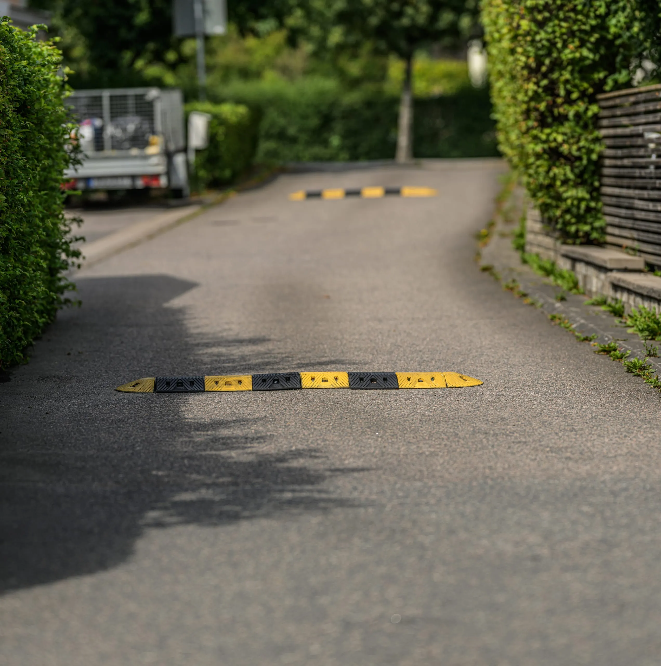 Ralentisseurs modulaires noirs et jaunes installés sur une voie asphaltée